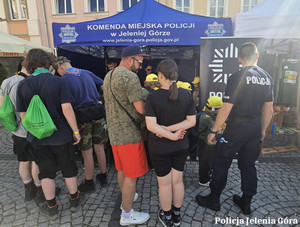 ludzie przy namiocie policyjnym podczas festynu