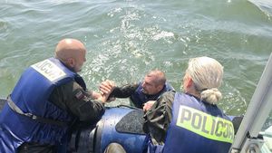 policjantka i policjant wyciągają mężczyznę z wody