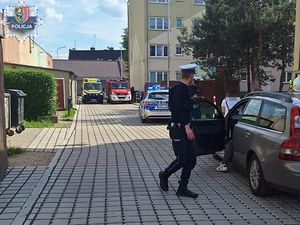 policjant podchodzi do samochodu osobowego w którym siedzi kierowca