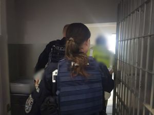 policjantka i policjant przy pomieszczeniu z kratami