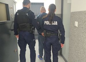 policjanci prowadzą zatrzymanego