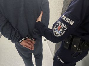 policjant prowadzi zatrzymanego