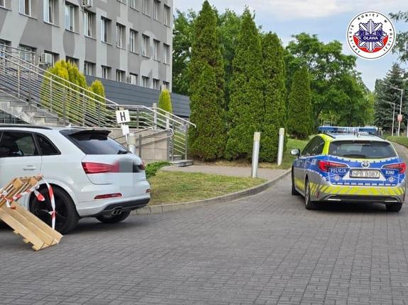 radiowóz eskortuje samochód osobowy do szpitala