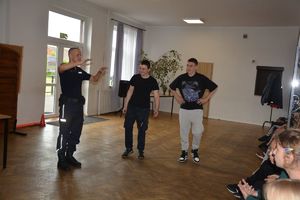 dzieci w wieku szkolnym w trakcie spotkania profilaktycznego, które prowadzi umundurowany policjant