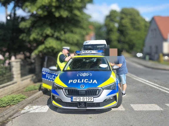 Umundurowani policjanci w trakcie wykonywania czynności służbowych, czyli kontrola drogowa oraz obsługa drona.