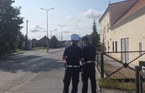 Umundurowani policjanci w trakcie wykonywania czynności służbowych, czyli kontrola drogowa oraz obsługa drona.