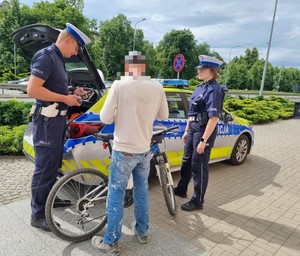 policjant i policjantka kontrolują rowerzystę