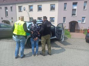 policjanci prowadzą zatrzymanego mężczyznę