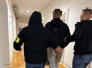 policjanci prowadzą zatrzymanego mężczyznę