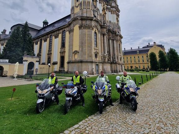 czterech policjantów na motorach w tle zabytkowy budynek