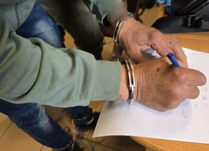 mężczyzna w kajdankach na rękach