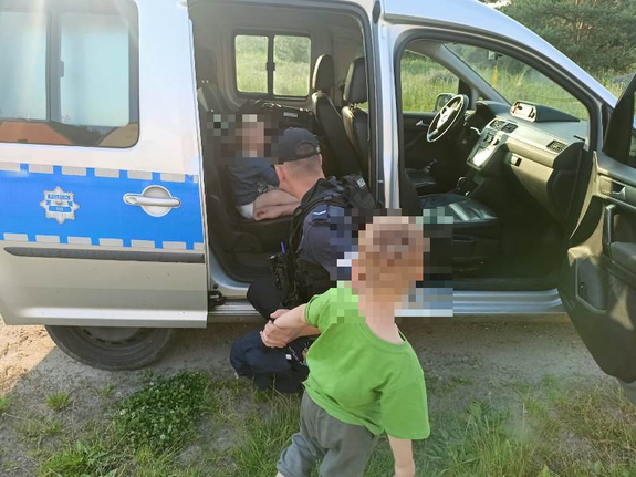 policjant z chłopcami w radiowozie