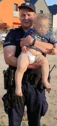 policjant z chłopcem na rękach