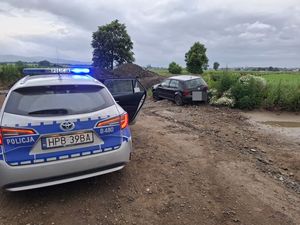 radiowóz na przedzie z tylu samochód osobowy