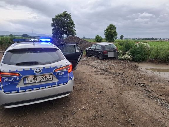 radiowóz na przedzie z tylu samochód osobowy