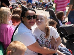kobieta trzymająca na rękach dziewczynkę na kolanach