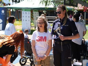 policjantka z mikrofonem obok dziewczynka