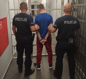 dwaj policjanci prowadzą zatrzymanego