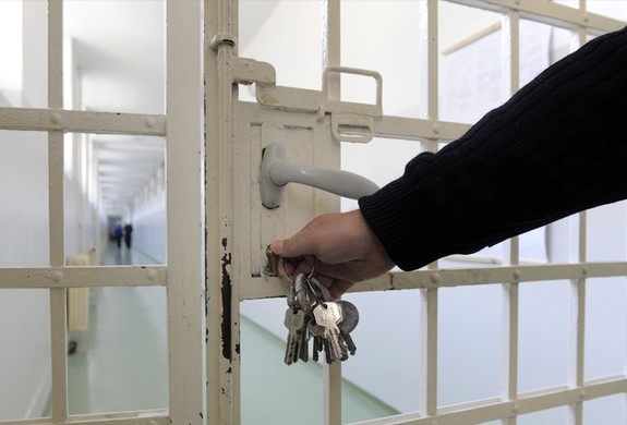 policjant zamyka drzwi kraty