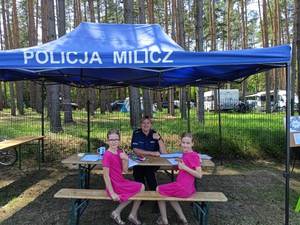 policjantka z dwiema dziewczynkami w namiocie policyjnym
