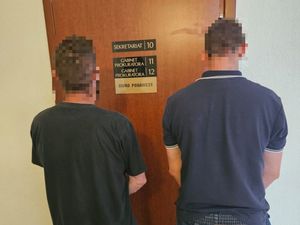 dwaj zatrzymani mężczyźni przed sekretariatem prokuratury