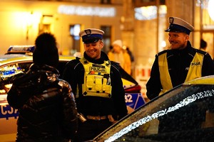 uśmiechnięci policjanci przy radiowozie