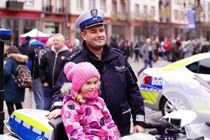 policjant obok dziecka siedzącego na motorze policyjnym