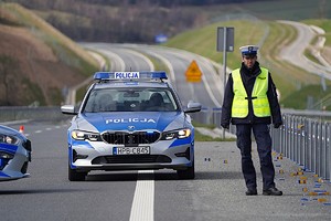 policjant na drodze przy radiowozie