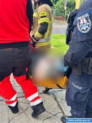 policjanci strażacy i medycy przenoszą mężczyznę