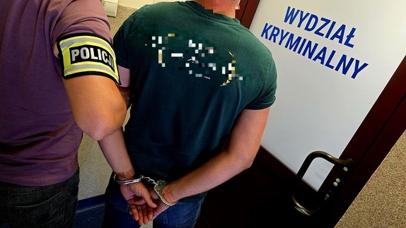 policjant prowadzi skutego w kajdanki mężczyznę