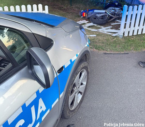 radiowóz przed nim zniszczony plot i leżący motor
