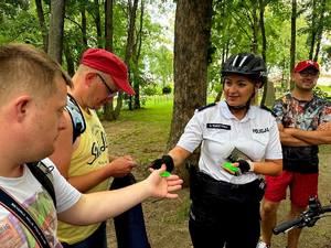 Umundurowane policjantki na rowerach z grupą napotkanych podopiecznych fundacji  z Warsztatów Terapii Zajęciowej