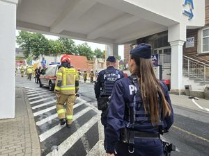 policjantka i policjant idą drogą za strażakami