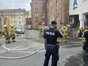 policjant dzwoni telefonem komórkowym wokolo straż pożarna