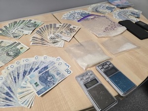 rozłożone w wachlarz banknoty w nominale polskim i narkotyki w woreczkach