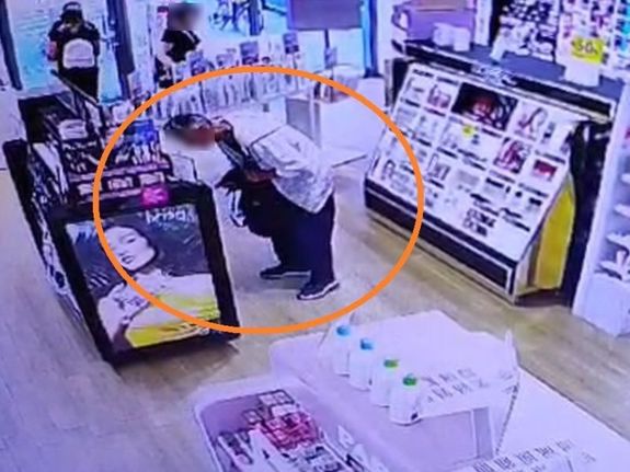 zdjęcie z kamery przemysłowej w sklepie pokazujące mężczyznę kradnącego towar