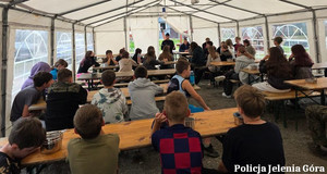 policjanci rozmawiają z harcerzami na obozowisku pod namiotem