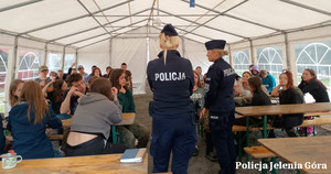 policjantki rozmawiają z harcerzami na obozowisku pod namiotem