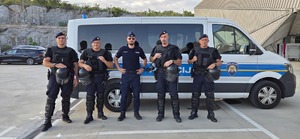 polski policjant z policjantami z Chorwacji przy radiowozie