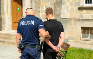 policjant prowadzi zatrzymanego mężczyznę