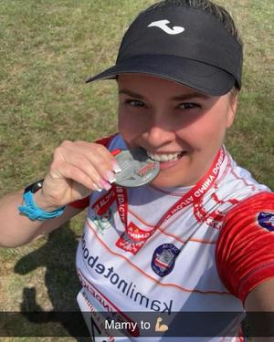 zdjęcie policjantki trzymającej w zębach medal