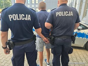 dwaj policjanci prowadzą zatrzymanego