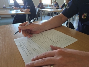 dłoń z długopisem nad kartką z testem