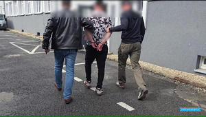 dwaj policjanci prowadzą zatrzymanego