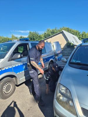 policjanci pomagają przy samochodzie