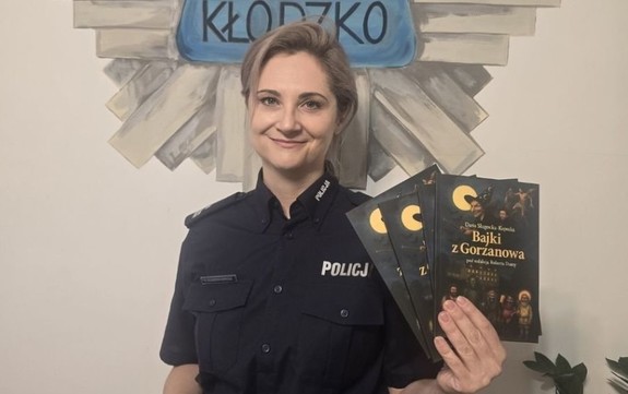 policjantka  z książeczkami dla dzieci w rękach