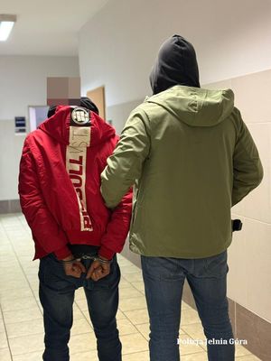 policjant prowadzi zatrzymanego