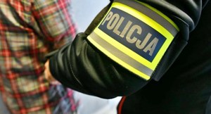 policjant prowadzi zatrzymanego