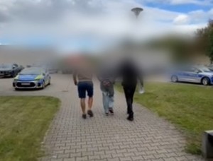 dwaj policjanci prowadzą zatrzymanego