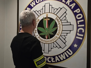 policjant operacyjny z opaską na ramieniu z napisem policja
